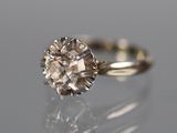 a close up of a diamond ring on a reflective surface