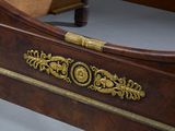 a bed with a wooden headboard with gold decorations on it