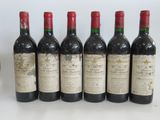 six bottles of wine are lined up in a row on a table