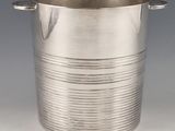 silver plated ice bucket with handles and handles on a grey background