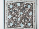 une photo d'une écharpe noire et blanche ornée de fleurs bleues