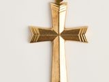 une image représentant un pendentif en forme de croix en or sur fond blanc