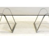 an image of a glass table with metal legs and a glass top