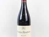 une bouteille de vin rouge posée sur une table blanche