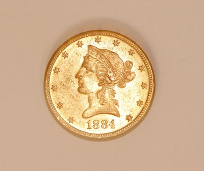 a close up of a gold coin with a woman ' s head on it
