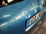 a close up of a blue car with a number plate on it