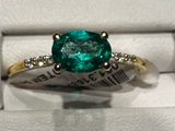 un gros plan d'une bague sertie d'une pierre verte