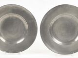 pair of silver plates on stands on a white surface