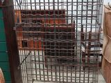 une grande cage métallique contenant tout un tas de bouteilles
