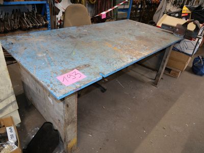 une table sur laquelle est posé un panneau, au milieu d'une pièce