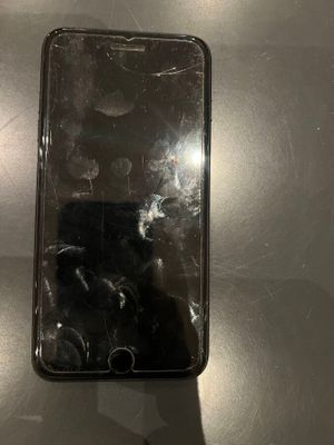 an iphone with a cracked screen sitting on top of a table