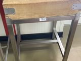 une table en bois avec un piètement en métal, sur laquelle se trouve un sac