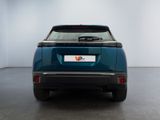 the rear end of a blue car in a room with a white wall