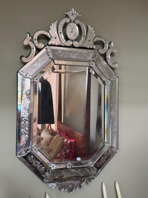 un miroir accroché au mur, avec des bougies et un porte-manteau