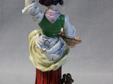 a figurine of a woman with a pot on her head