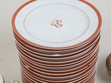 a stack of orange and white plates on a table