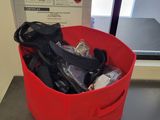 a red basket filled with hair dryers on a table