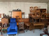 une pièce avec beaucoup de meubles et un fauteuil bleu