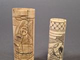 two old carved wooden cylinder holders sitting on top of a table