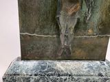 a statue of a man holding a bird on a marble base