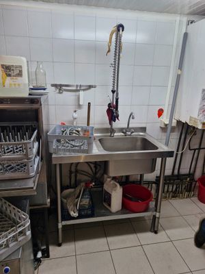a kitchen with a sink and a lot of utensils on the counter