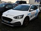 a white ford focus parked in a lot with other cars