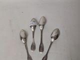 four spoons and a spoon rest on a white surface