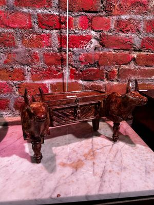 une statue représentant un taureau et une table sur laquelle se trouve une lampe