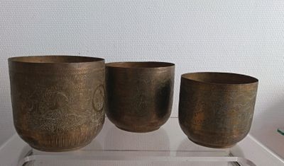 three cups sitting on a clear shelf next to each other