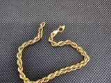 un bracelet à chaîne en or avec un fermoir sur fond noir