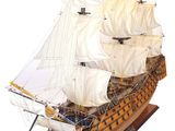 tall wooden model of a sailing ship on a wooden stand