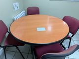 une table ronde entourée de quatre chaises dans une pièce