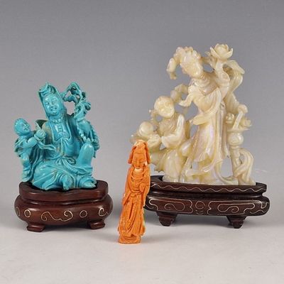 trois figurines chinoises sculptées représentant une femme et un homme, posées sur un socle