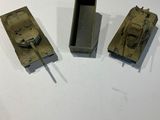 three toy tanks sitting on top of a white table next to each other