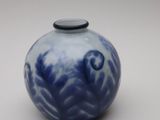 a blue and white vase with a black lid on a white surface