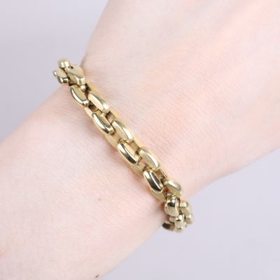 a close up of a person ' s hand wearing a gold bracelet