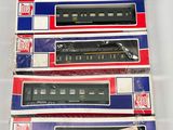 quatre wagons fermés sont alignés sur une surface blanche