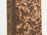 a brown and black book sitting on top of a white table