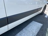 a white van with black stripes parked in a parking lot