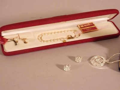un écrin rouge contenant des perles et une paire de boucles d'oreilles