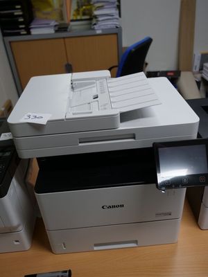 a printer sitting on top of a desk next to a cell phone