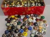 une boîte rouge remplie d'une multitude de capsules de bière