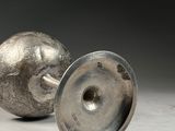two silver vases sitting on a white surface