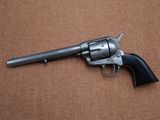 a revolver with a wooden handle on a brown background