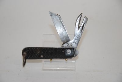 a small knife with a black handle on a white surface