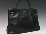 a black leather handbag on a white surface