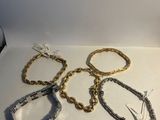 several bracelets and a bottle of wine sit on a table