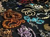 de nombreux types de perles et de colliers posés sur une table