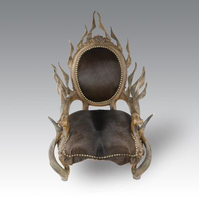 une chaise avec des cornes sur le dossier et une assise en cuir