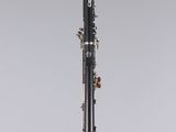 a black and silver clarinet sitting on top of a clear stand